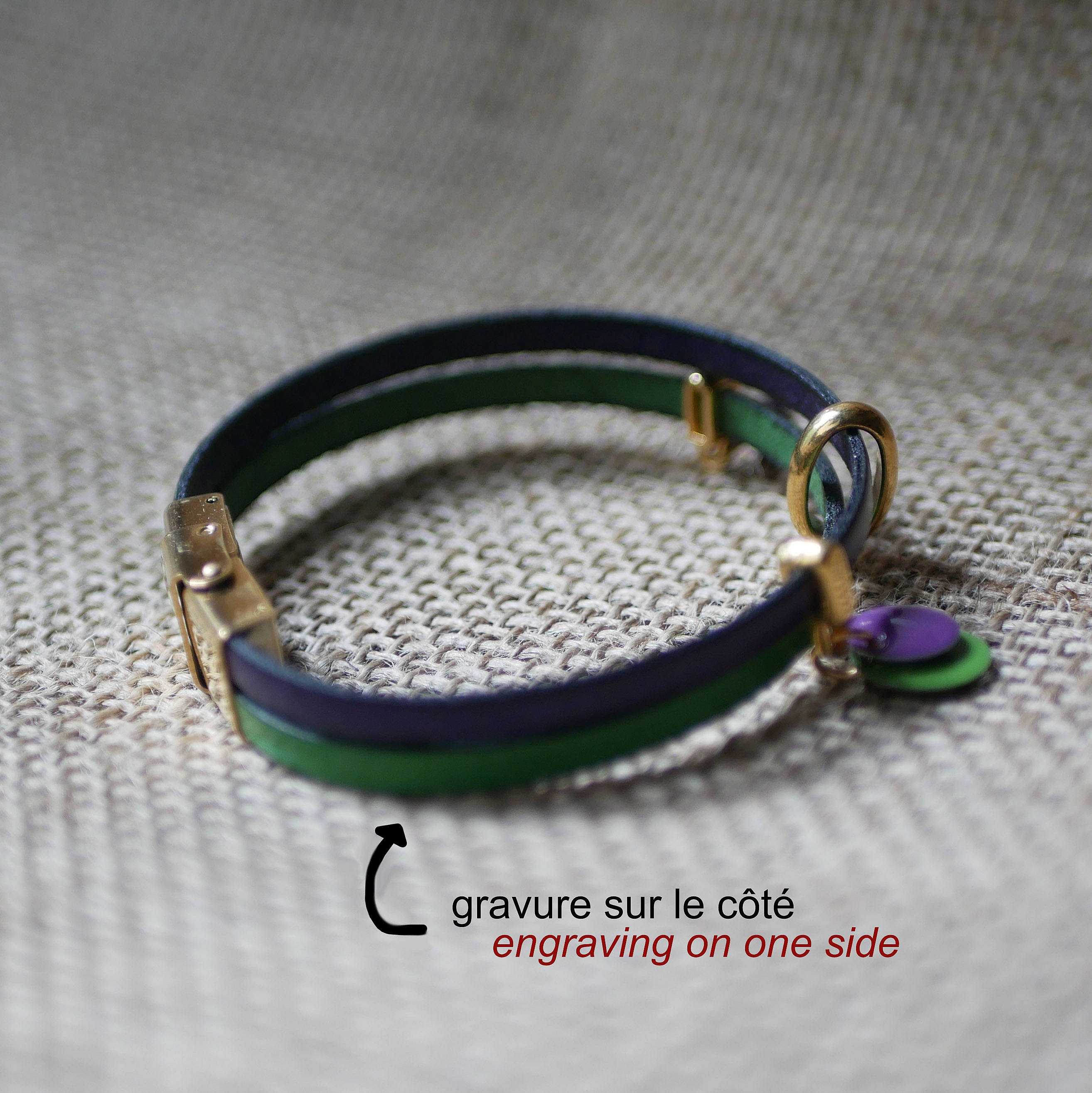 Bracelet duo cuir violet vert avec breloques dorées gravées.