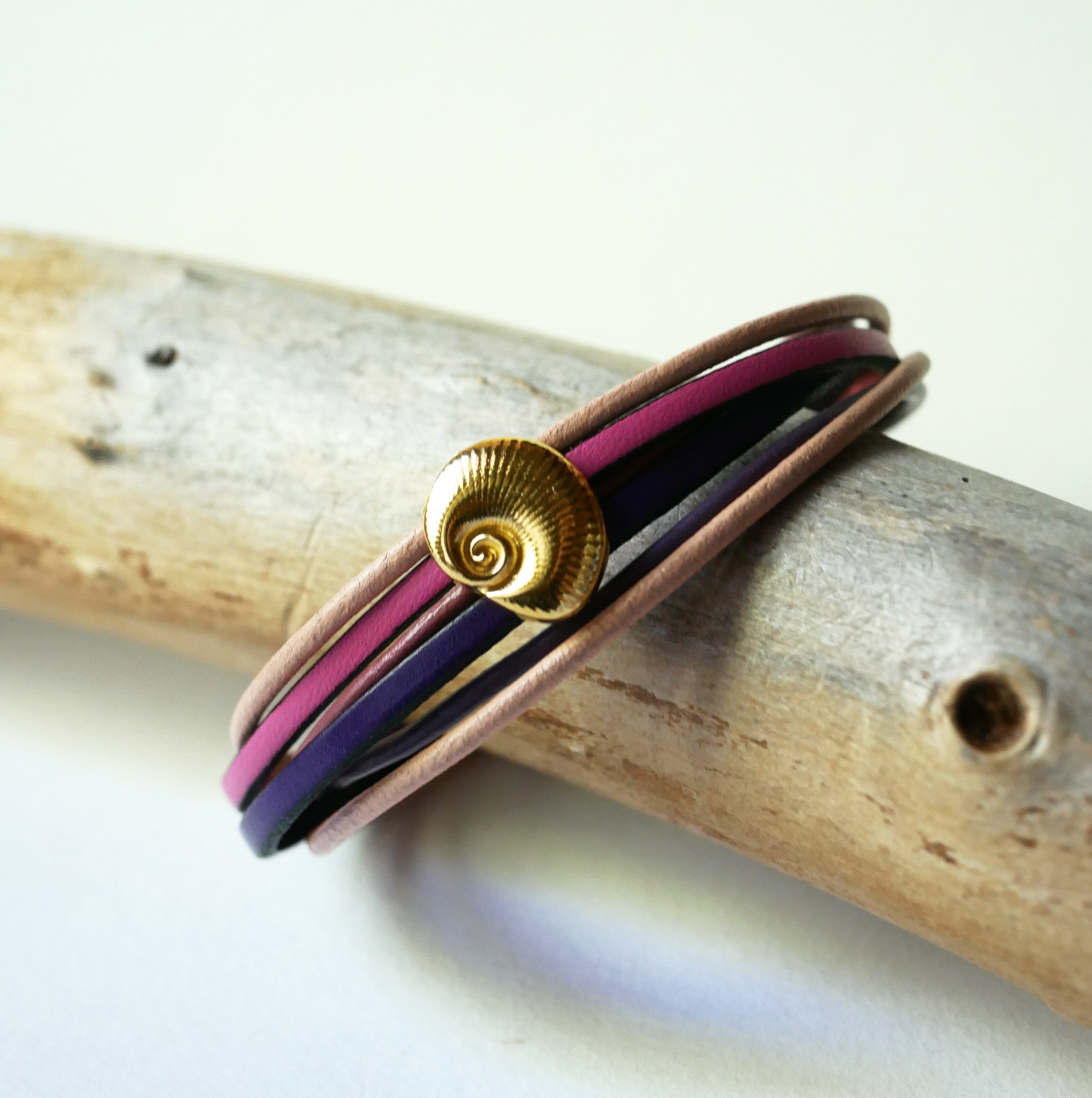 Bracelet multi-liens cuirs tons p&ecirc;ches et mauves d&eacute;cor coquillage dor&eacute;