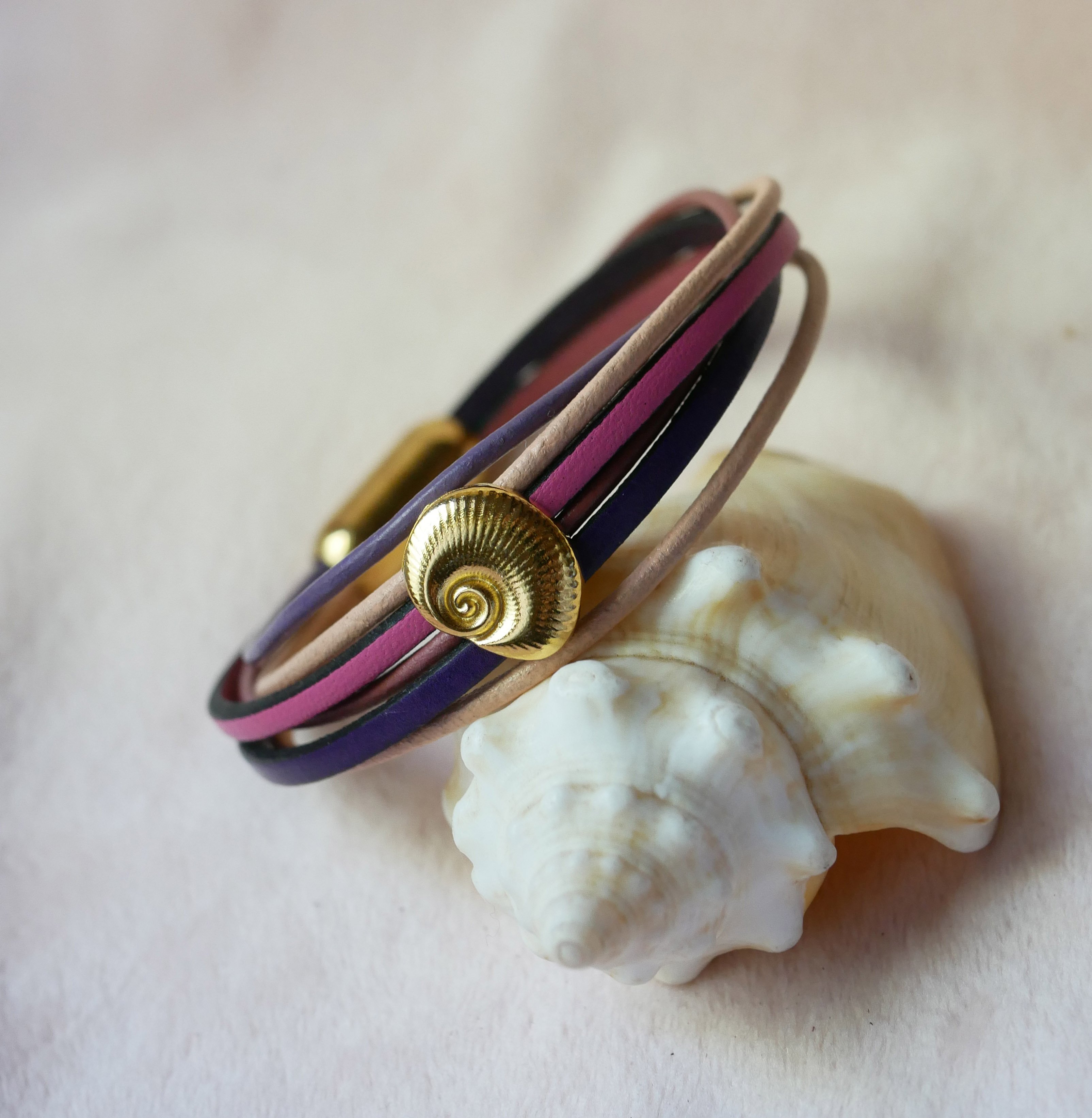 Bracelet multi-liens cuirs tons p&ecirc;ches et mauves d&eacute;cor coquillage dor&eacute;