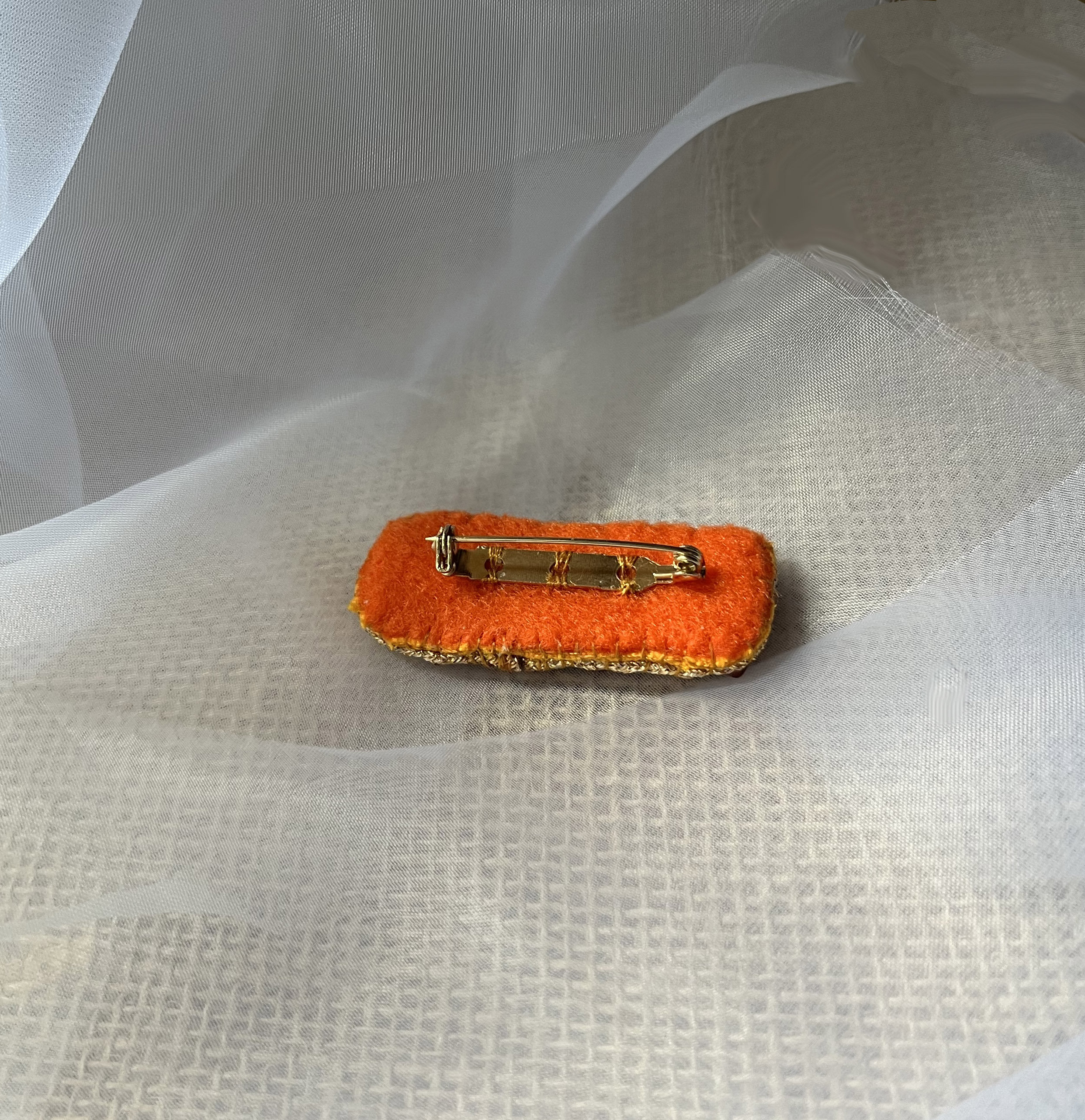 Broche à message en cuir gravé "sois béni" en perles rouges et dorées 